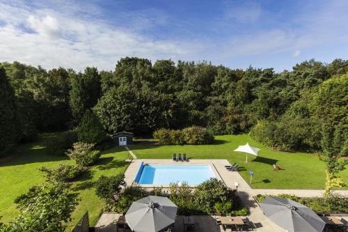 埃因霍温埃因霍温诺富特酒店的享有花园和游泳池的空中景致