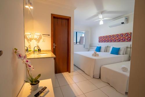 塞古罗港DUPLEX 2 SUÍTES CONDOMÍNIO MONT CARMELO的客房设有两张床和一间带水槽的浴室