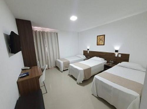 保罗阿方索城Hotel Bellavista的酒店客房设有两张床和电视。