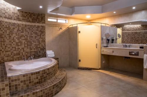 埃莫西约Hotel Santorian的一间带大浴缸和水槽的浴室