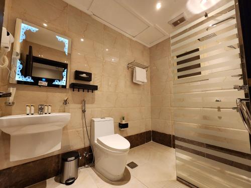 吉达Rasis Furnished Apartments的浴室配有卫生间、盥洗盆和淋浴。
