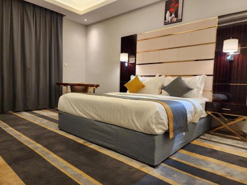 吉达Rasis Furnished Apartments的酒店客房设有一张大床和一张书桌。