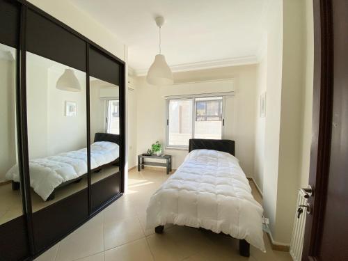 安曼360 Rooftop Apartment in Dabouq的一间卧室配有一张大床和镜子