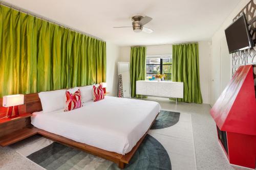 圣徒皮特海滩Sunset Inn and Cottages的一间卧室配有一张带绿色窗帘的大床