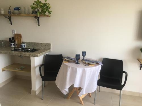 伊卡普伊Sua casinha de férias em Icapui CE的一张桌子、椅子和白色的桌布