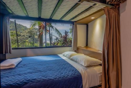 拉利伯塔德Lagarza Hostel的一间卧室设有一张蓝色的床和大窗户