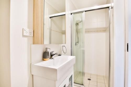 卡拉拉海滩Hayes Beach House I Award Winner I 4 Mins to Beach的白色的浴室设有水槽和淋浴。