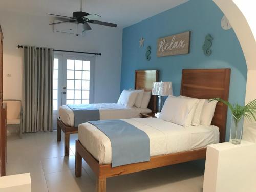 尼格瑞尔Sommerville Resorts的一间卧室设有两张床和蓝色的墙壁