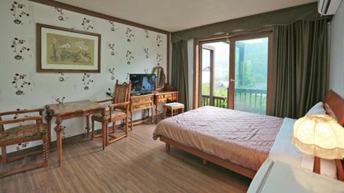 平昌Chalet Resort的一间卧室配有一张床、一张桌子和一张书桌。