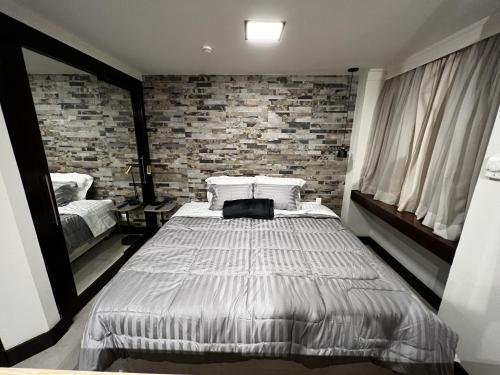 圣保罗Flat - Al Santos - Prox Av Paulista的一间卧室设有一张床和砖墙