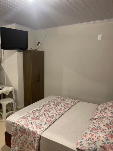 伊塔佩马Itapema Suítes的一间卧室设有两张床,墙上配有电视。