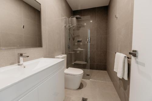 卡拉拉海滩Beach & Bay Stay Motel的一间带水槽、卫生间和淋浴的浴室