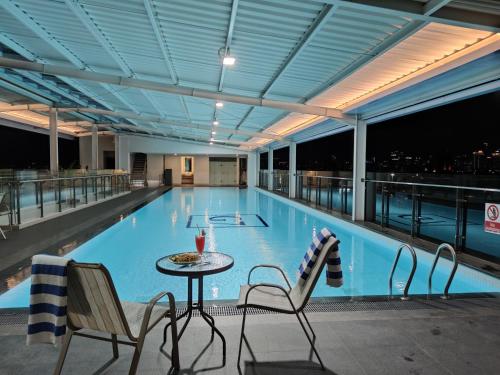 雅加达Grand G7 Hotel Pasar baru的一个带桌椅的大型游泳池