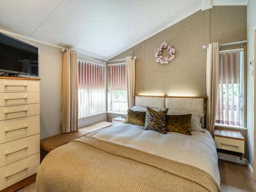 格兰奇奥沃桑茨Links Lodge的一间卧室设有一张床、一台电视和窗户。