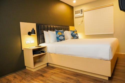 长滩岛Kommons by Kamino的卧室配有一张白色的大床和床头柜。