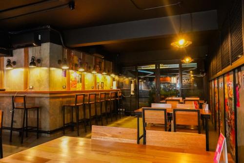 长滩岛Kommons by Kamino的餐厅设有酒吧和桌椅
