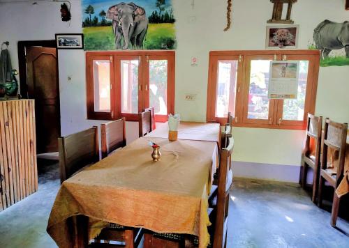 BhurkīāJungle Heaven Hotel and Cottage的一间用餐室,配有一张桌子和墙上的大象