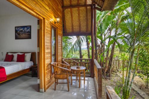 珀尼达岛Indah Guest House Nusa Penida的卧室配有一张床和一张桌子及椅子