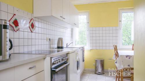 莫尔斯Zimmer im Herzen von Moers的厨房拥有黄色和白色的瓷砖墙壁