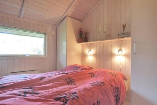 博托比Sommerhus i Marielyst m/Spa og sauna - tæt på by og strand的一间卧室配有一张带粉色毯子的床