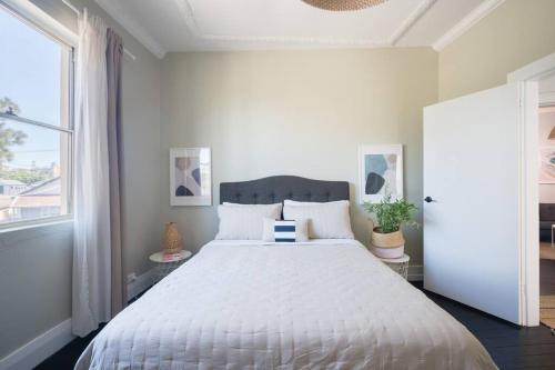 悉尼Beautiful 2BR Top Floor Bondi Beach Walk to Beach的一间卧室配有一张带白色床罩的大床