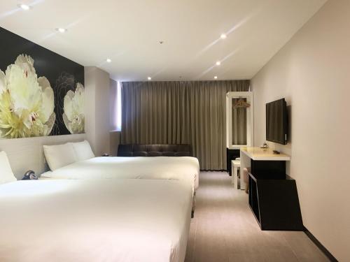 台北禾顺行旅 的酒店客房设有两张床和电视。