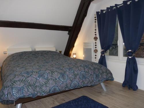 索姆河畔的圣瓦列里Gîte d’Eros的一间卧室配有蓝色窗帘的床