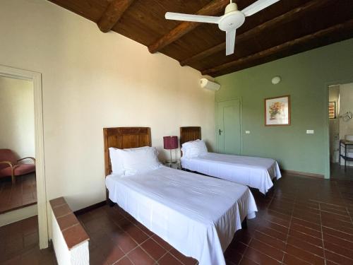 卡尔马尼奥拉玛格丽特拉乡村民宿的一间卧室配有两张床和吊扇
