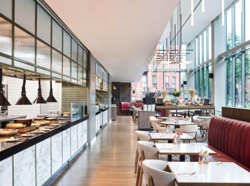 曼彻斯特Hyatt Regency Manchester的餐厅设有桌椅和窗户。