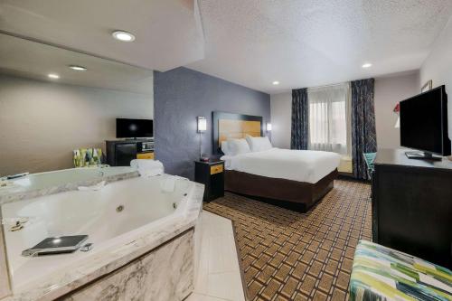 丹顿Quality Inn - Denton的酒店客房设有大浴缸和一张床