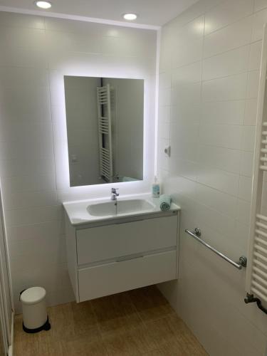 科马鲁加Amazing in front of the sea apartment的白色的浴室设有水槽和镜子