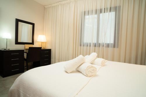 戈梅拉岛圣塞瓦斯蒂安Holiday House Penthouse in La Gomera的卧室配有白色的床和3个枕头