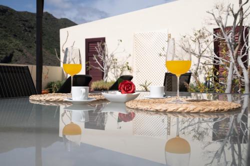 戈梅拉岛圣塞瓦斯蒂安Holiday House Penthouse in La Gomera的天井上的桌子和两杯葡萄酒