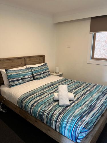 芒特比尤蒂Snow View Holiday Units的一间卧室配有一张床,上面有两条毛巾