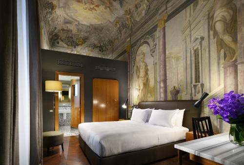 佛罗伦萨Hotel Garibaldi Blu - WTB Hotels的一间卧室配有一张床,天花板上装饰有绘画作品