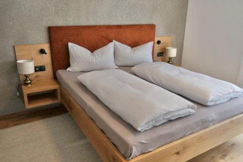 佩尔卡BioTop Appartement Kronplatz的一张配有白色床单和枕头的大床
