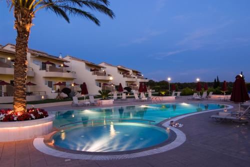 卡洛吉亚Verde Al Mare Boutique Hotel的夜间在酒店前的游泳池