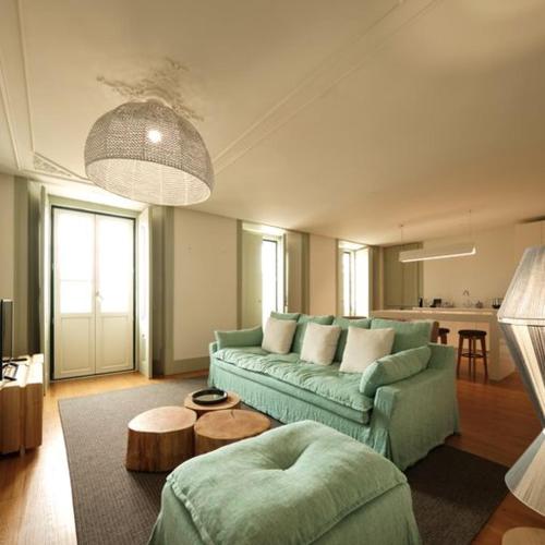 里斯本Look Living, Lisbon Design Apartments的客厅配有绿色沙发和桌子
