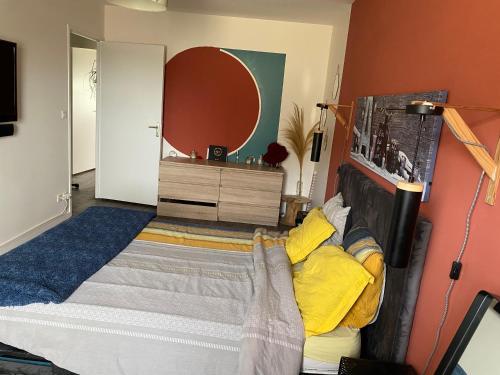 阿纳齐Maison cosy Arnage的一间卧室配有一张带黄色枕头的床