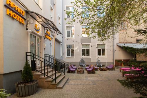 利沃夫Stories Hub的一座带紫色椅子的酒店庭院和一座建筑