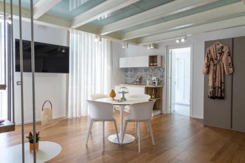 巴勒莫Peonia Boutique Apartments的一间配备有白色桌椅的用餐室