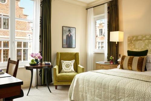布鲁塞尔阿米戈罗科富酒店的一间卧室配有一张床、一把椅子和窗户。