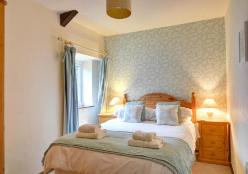 LlanerchymeddSwallow Cottage的一间卧室配有带毛巾的床