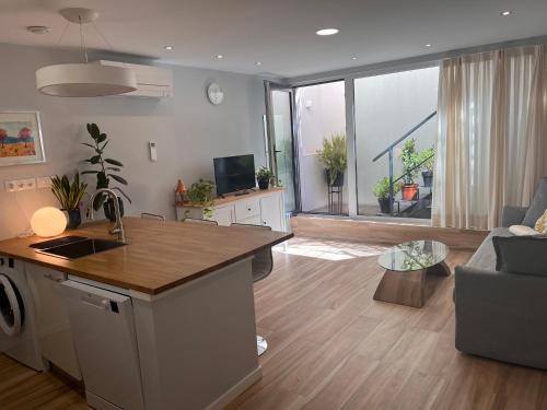 马德里Modern Apartment by the Airport IFEMA - 1 Bedroom的一间带厨房的客厅和一间带沙发的客厅