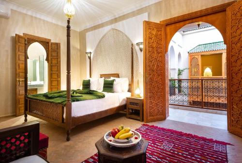 马拉喀什Palais Tara & Spa的一间卧室,配有一张床上的床铺,桌上放着一碗水果