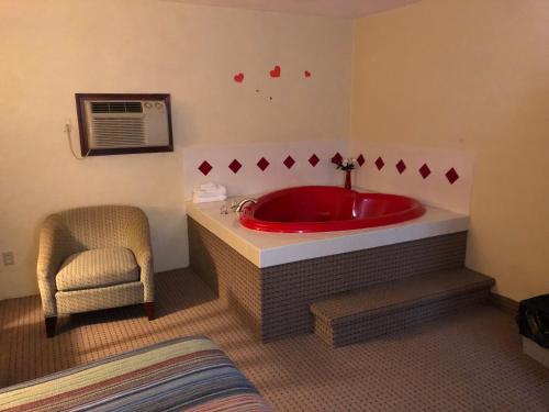 米兰诺Motel Boutique by Wolf Inn的一间带红色浴缸和椅子的浴室