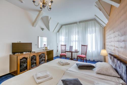 布拉索夫安纳波利斯中央酒店的卧室配有一张床和一张桌子及椅子