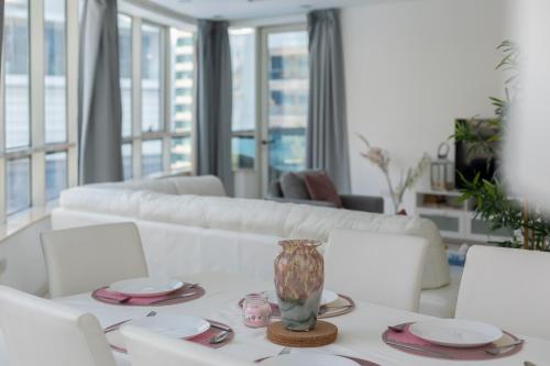 迪拜Dubai Marina - 5 bedroom, resort feel, great Amenities的客厅配有白色桌子和花瓶