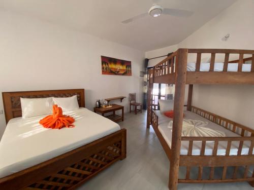 帕杰Amani Hotel Paje的一间卧室设有两张双层床,床上有橙花