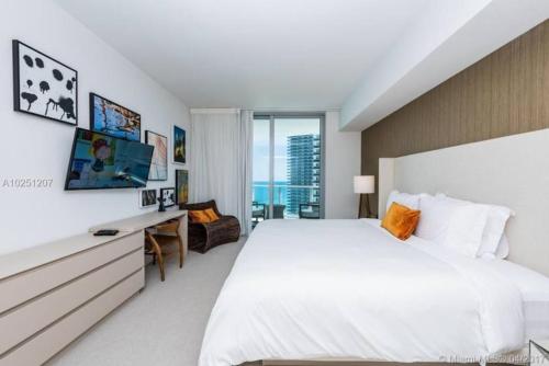 好莱坞Modern Beachfront Condo with Stunning Ocean View的卧室配有一张白色大床和一张书桌
